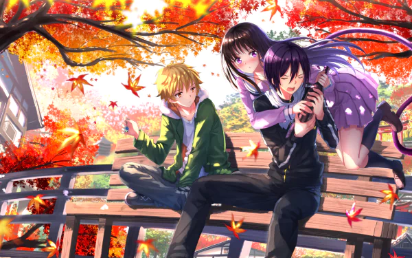 HD desktop wallpaper featuring Yukine, Hiyori Iki, and Yato from the anime Noragami, set in a vibrant autumn scene with colorful falling leaves and a wooden bridge.