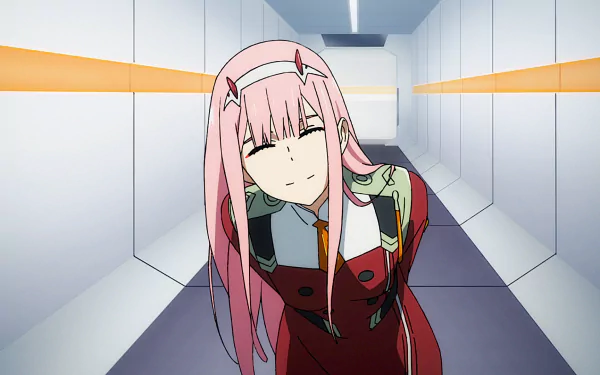 Zero Two from Darling in the FranXX, characterized by her pink hair, horns, and military uniform, stands in a hallway. This HD anime wallpaper captures her distinctive style and confident expression.